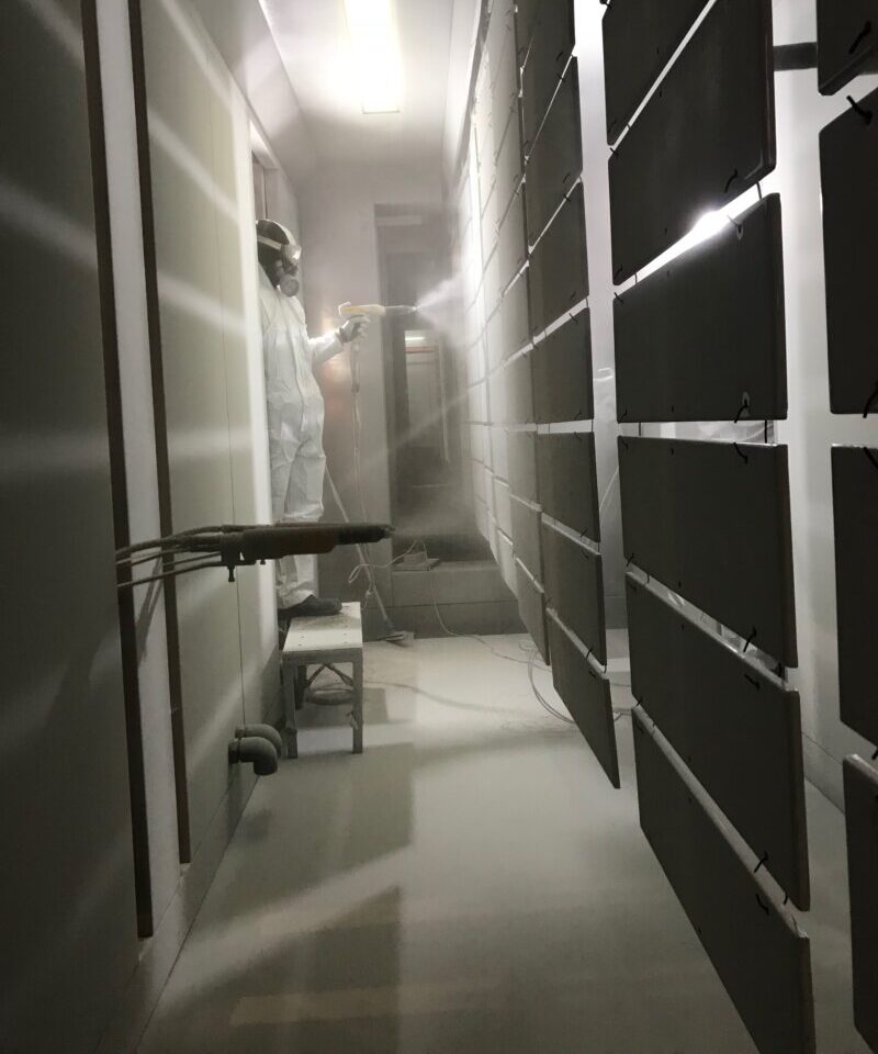 Operatore che applica verniciatura a polvere su componenti metallici presso Metal Paint.