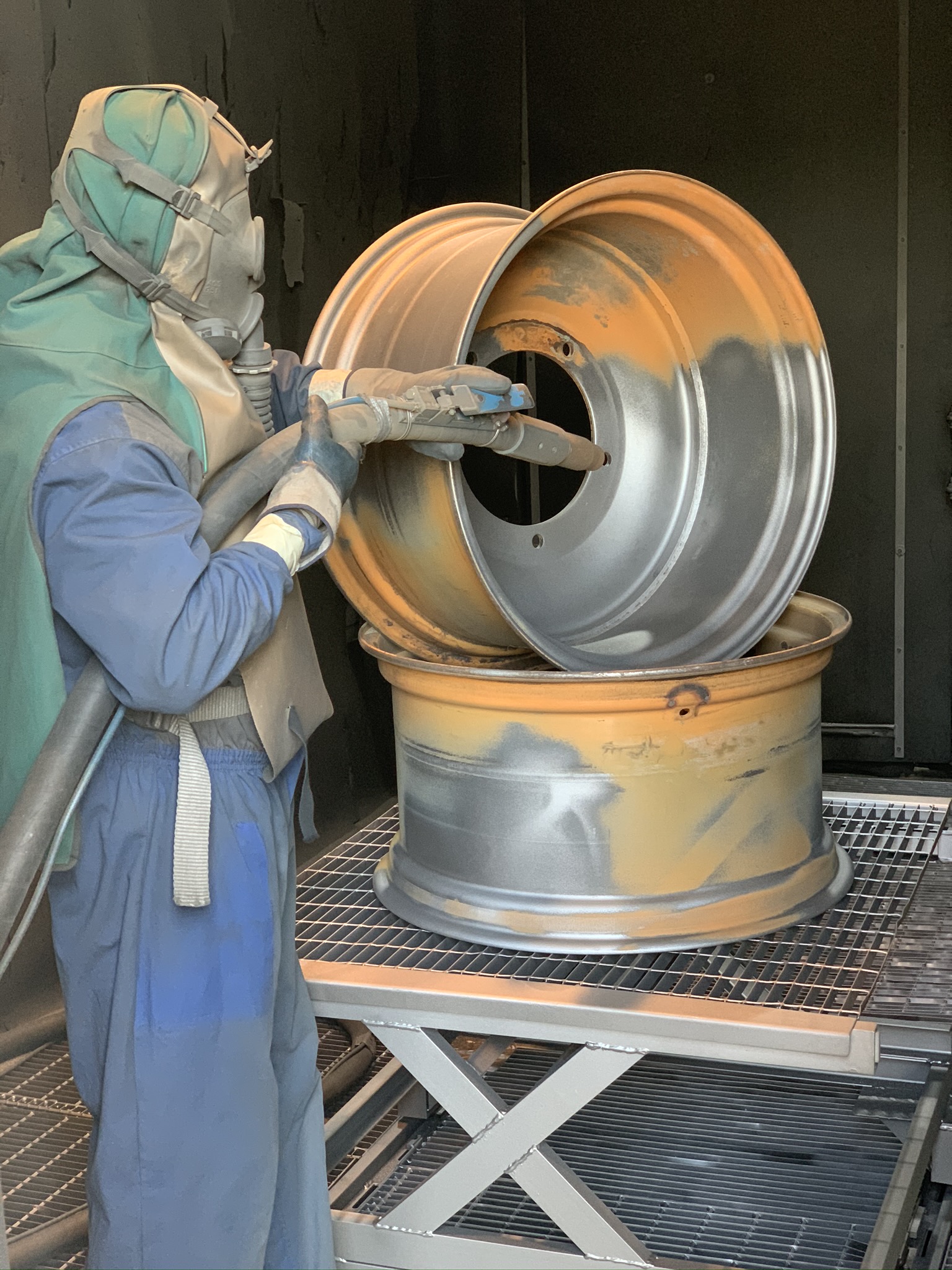 Operatore che effettua sabbiatura di cerchioni in lega e acciaio per auto, restauro Metal Paint.